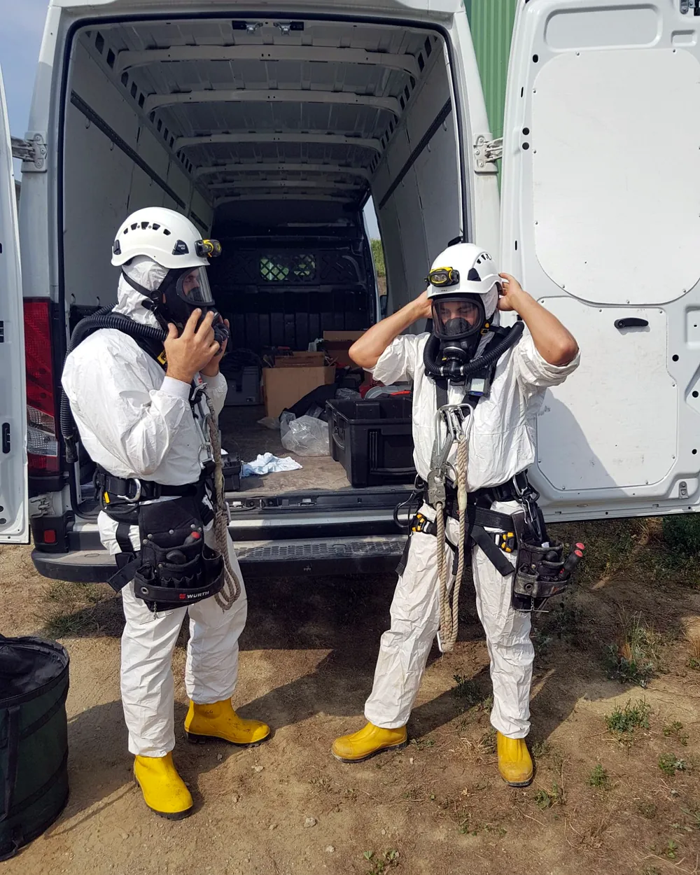 Due tecnici RGS indossano autorespiratore, tuta e imbragatura prima di entrare in uno spazio confinato dell'impianto