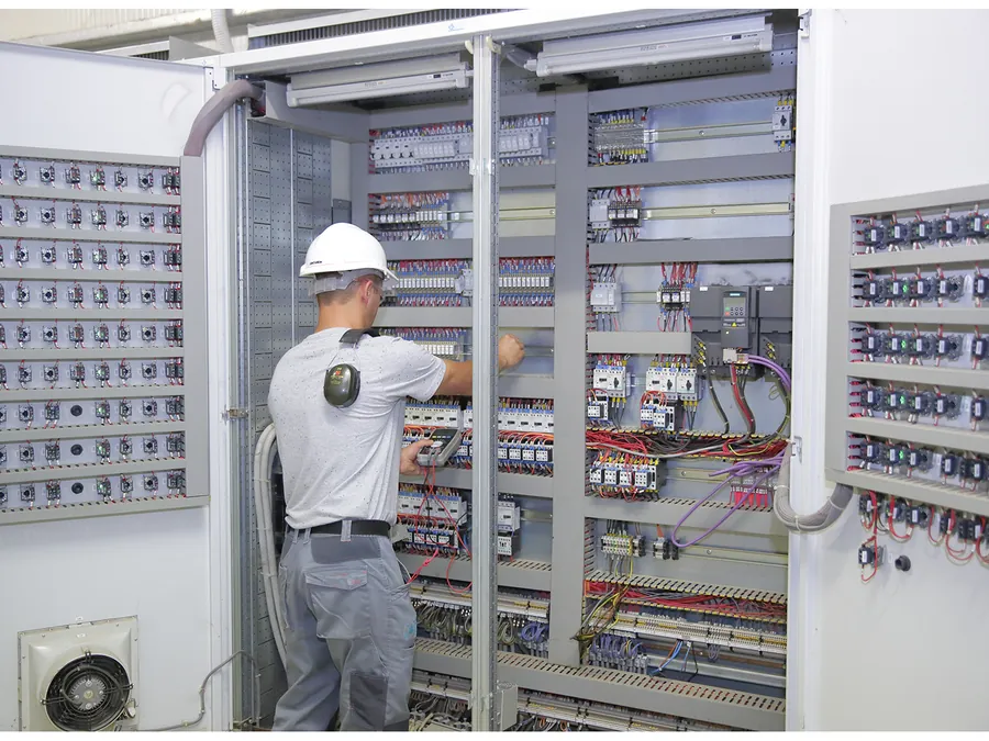 Tecnico RGS controlla il quadro elettrico di un impianto biogas durante una visita programmata